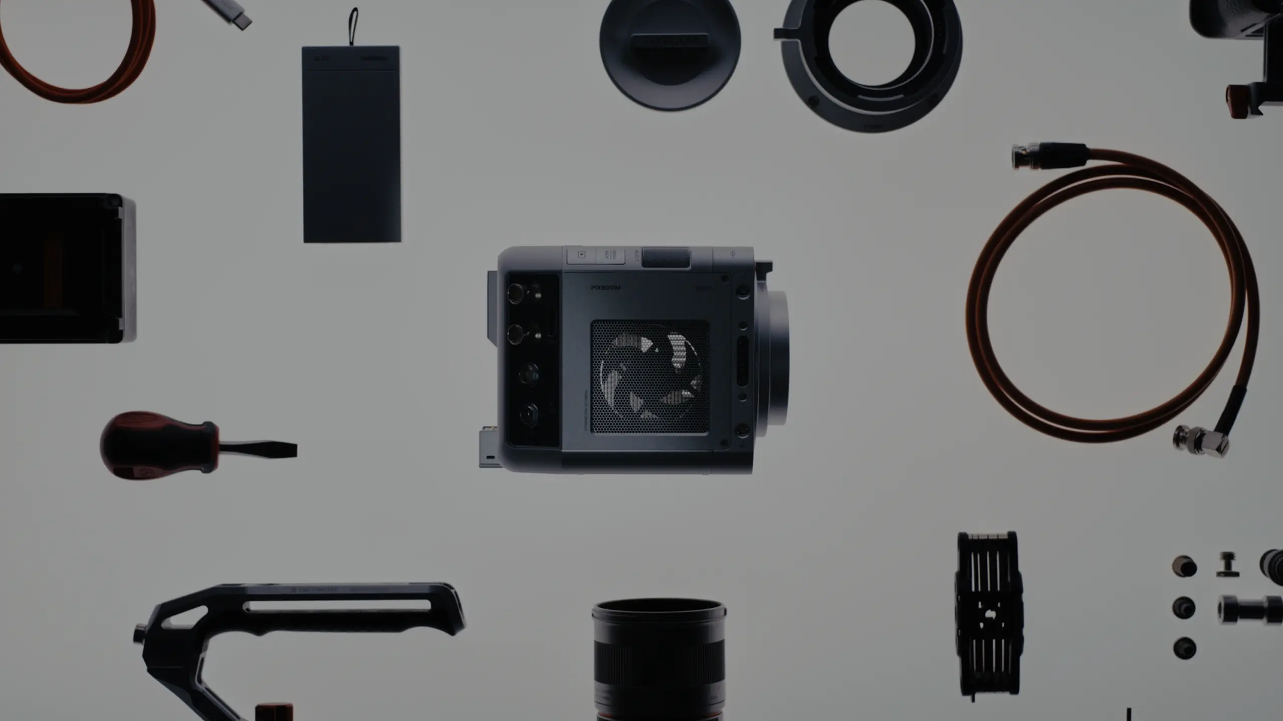 Spark camera surrounded by lenses, cables, tools and rig accessories laid out on a light surface