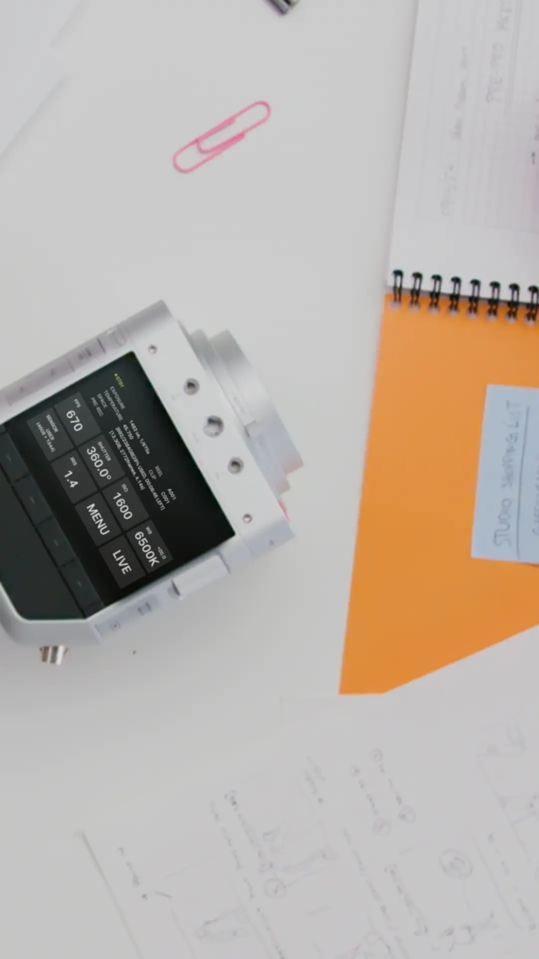 Overhead view of a designer’s desk with sketches, storyboards and a Spark camera among them