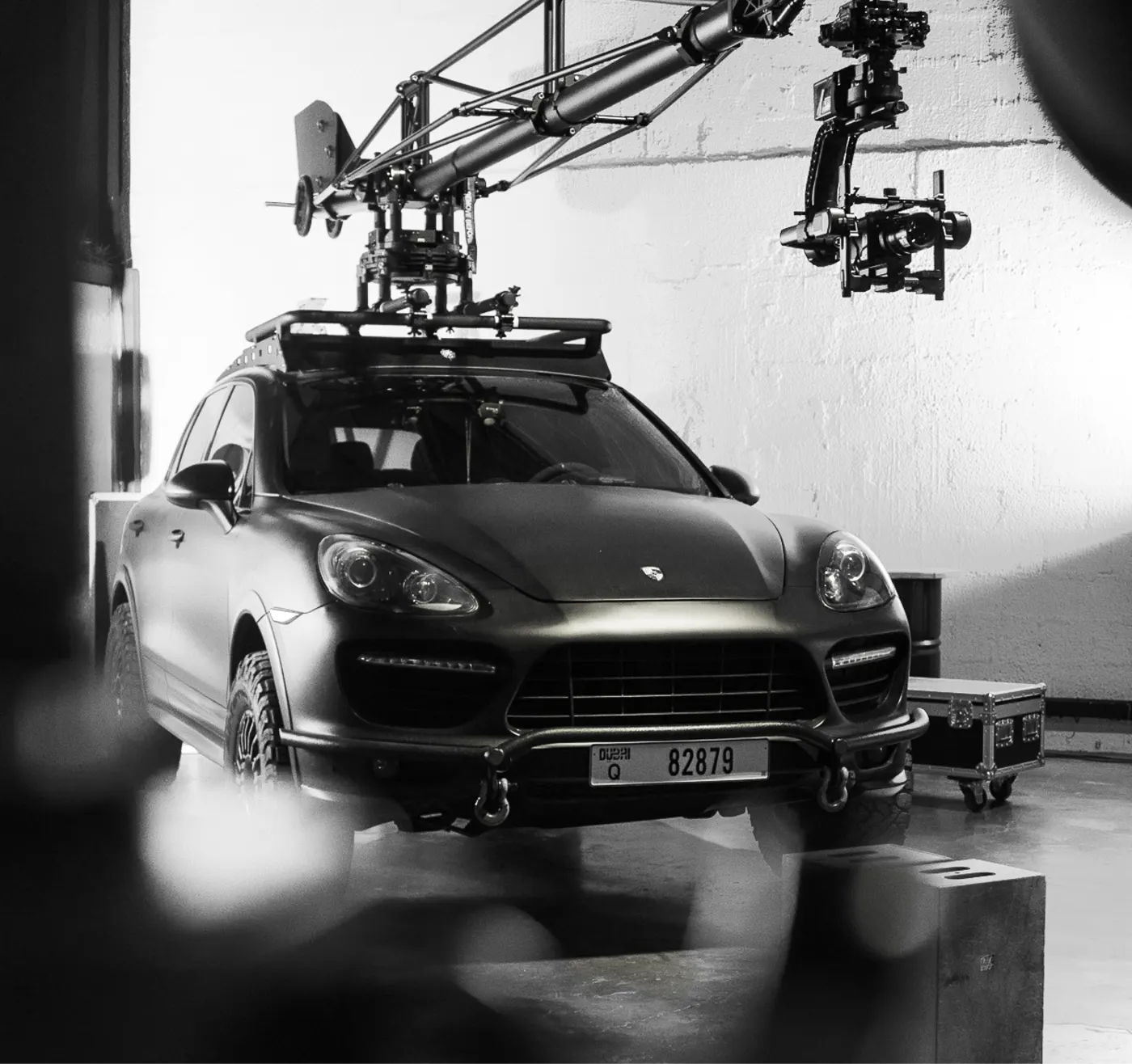 A car on a camera rig with a robotic crane arm in a studio